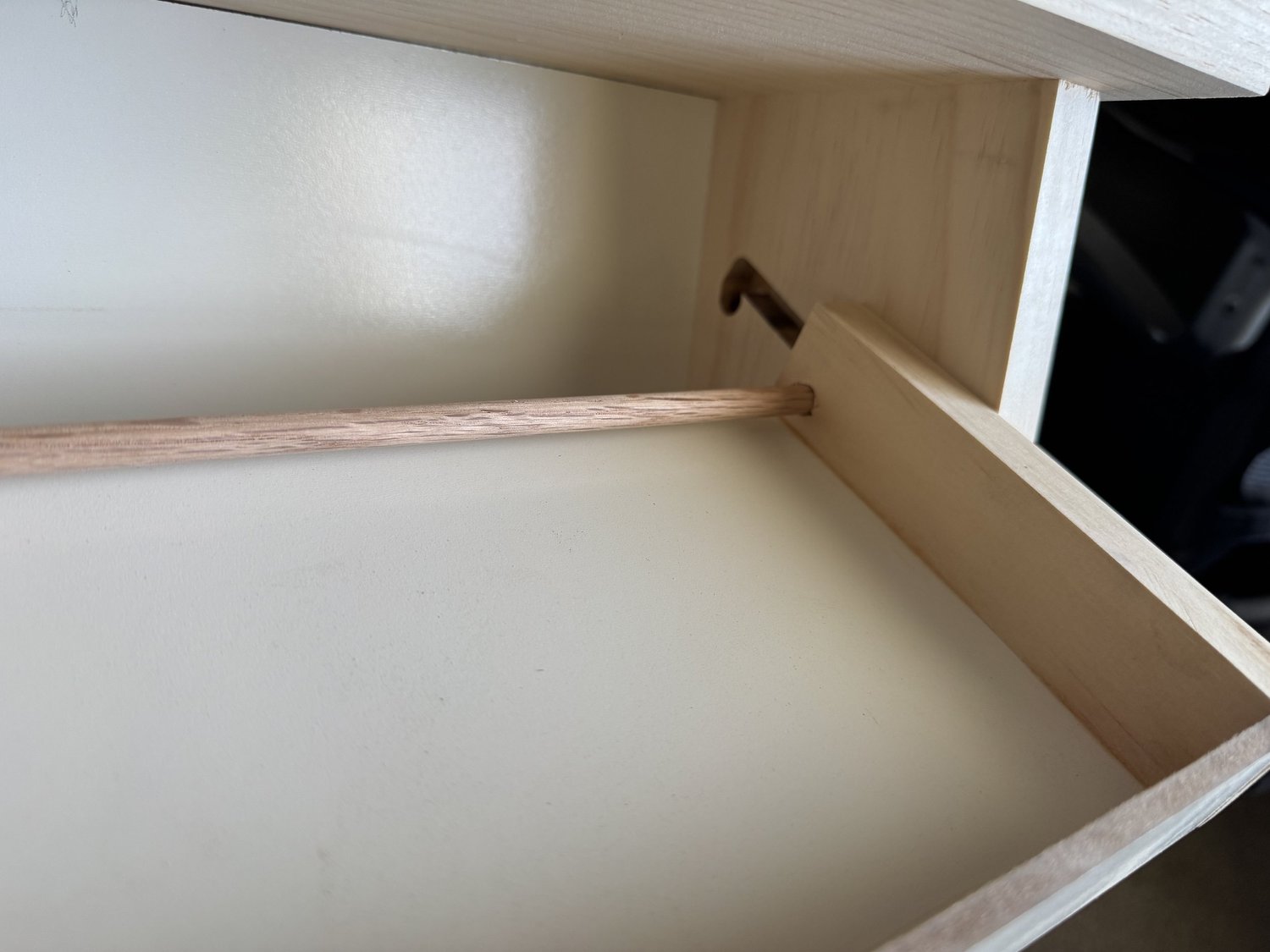 Close view of the oak dowel running through the shelf mechanism